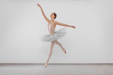 Young ballerina practicing dance moves in studio
