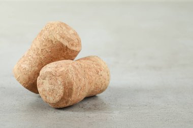Corks of wine bottles on light grey table, closeup. Space for text