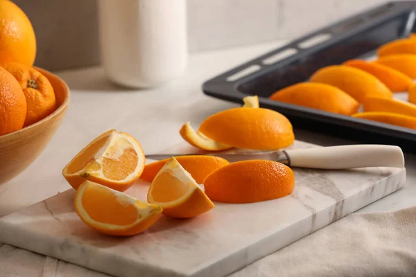 Fresh orange peels and juicy fruits on white table