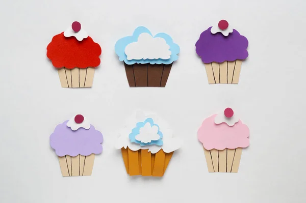 Different paper cupcakes on white background, flat lay