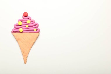 Ice cream cone made of plasticine on white background, top view