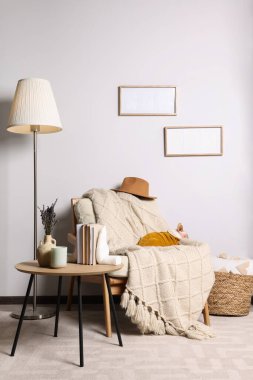 Cute Sphynx cat in warm sweater on armchair at home. Lovely pet