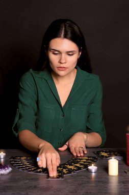 Kahin, siyah arkaplanda tarot kartlarıyla geleceği tahmin ediyor