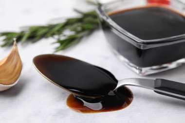 Organic balsamic vinegar and cooking ingredients on white table, closeup