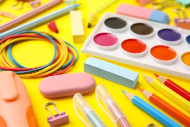 Different school stationery on yellow background, closeup. Back to school