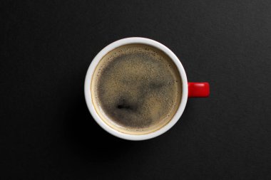 Siyah arka planda sıcak aromalı seramik fincan, üst manzara.