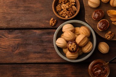 Ahşap masada haşlanmış konsantre sütle lezzetli fındık şekilli kurabiyeler. Metin için boşluk
