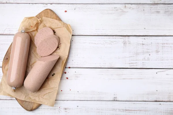 stock image Board with delicious liver sausage on white wooden table, top view. Space for text