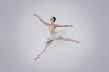 Young ballerina practicing dance moves on white background