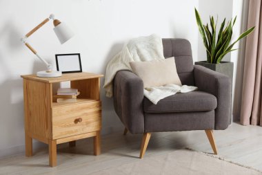 Rahat koltuk, masa lambası ve güzel dekor elementleriyle dolu rahat bir oda.