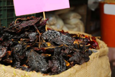 Çuval bezi içinde kurumuş siyah anço biberi yığını.