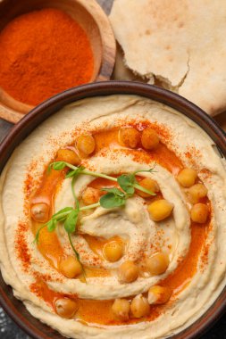 Nohutlu lezzetli humus ve gri masada farklı malzemeler var.