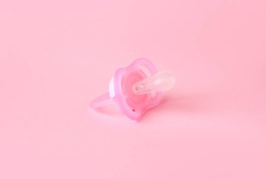 One new baby pacifier on pink background