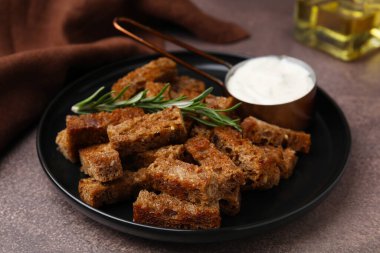 Crispy rusks with rosemary and sauce on grey table
