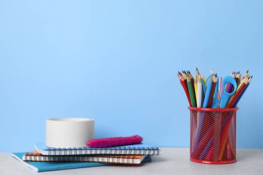 Different school stationery on table against light blue background. Back to school