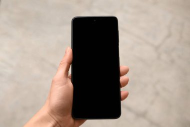 Elinde boş ekranlı akıllı telefon tutan kadın, yakın plan.