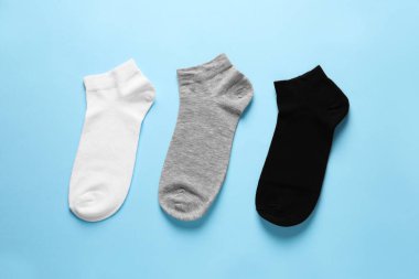 Different socks on light blue background, flat lay