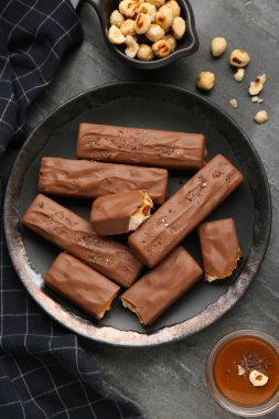 Lezzetli çikolata kalıpları, karamel ve fındıklar siyah masada, düz yatıyordu.