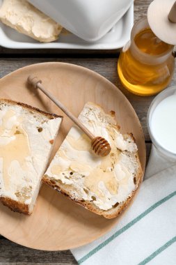 Tahta masada tereyağlı, ballı ve sütlü dilimler, düz uzanmış.
