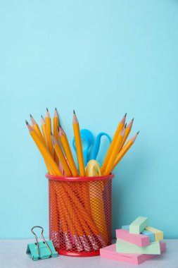 Different school stationery on table against light blue background. Back to school