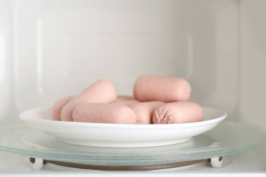 Mikrodalga fırında tabakta lezzetli sosisler. Et ürünü