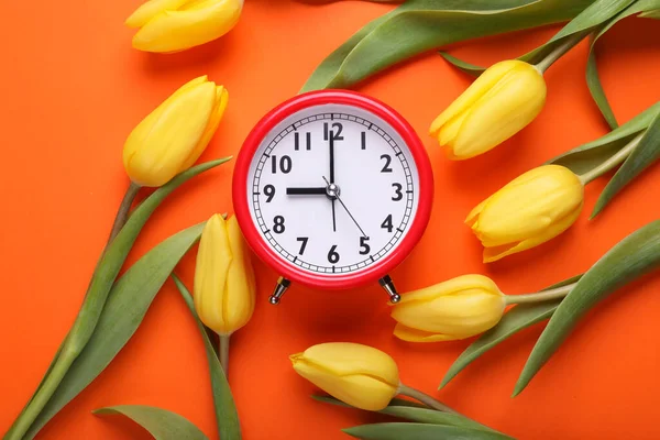 Rode Wekker Mooie Tulpen Oranje Achtergrond Plat Gelegd Voorjaarstijd — Stockfoto