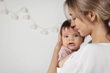 Anne küçük sevimli bebeğine evde sarılıyor, mesaj atmak için yer var.