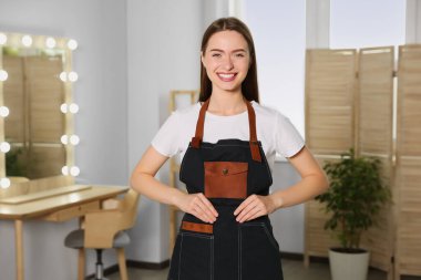 Güzellik salonunda önlük giyen profesyonel kuaför portresi.