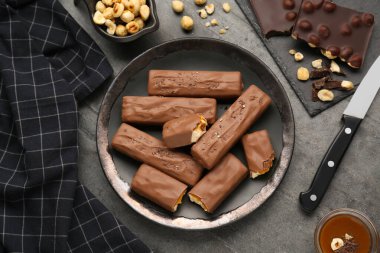 Lezzetli çikolata kalıpları, karamel ve fındıklar siyah masada, düz yatıyordu.