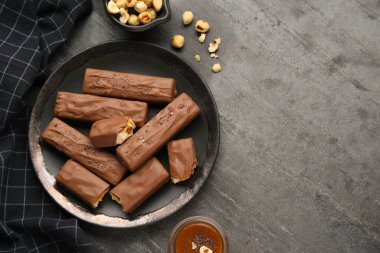 Lezzetli çikolata kalıpları, karamelli ve fındıklı siyah masa, düz yatak. Metin için boşluk