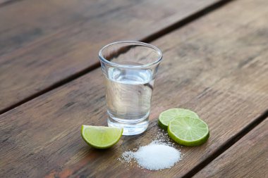 Limon dilimli Meksika tekilası ve ahşap masada tuz. Agave 'den yapılan içecek.