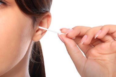 Woman cleaning ear with cotton swab on white background, closeup