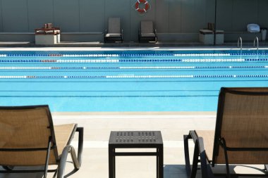 Tatil yerindeki açık yüzme havuzunun yanındaki boş güneşlik.