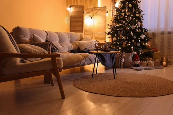 Beautiful room with sofa and tree decorated for Christmas. Interior design