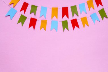 Pembe arka planda renkli bayraklar, düz yatış. Metin için boşluk