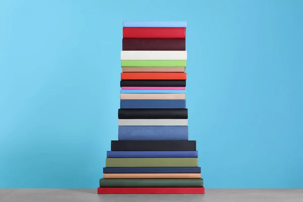 Stack of hardcover books on light blue background