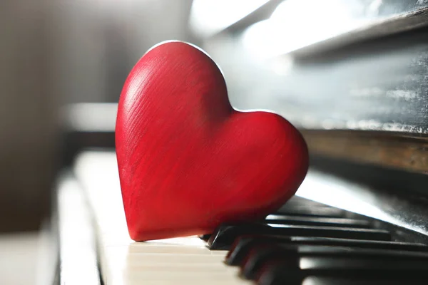 Red decorative heart on piano keys, closeup