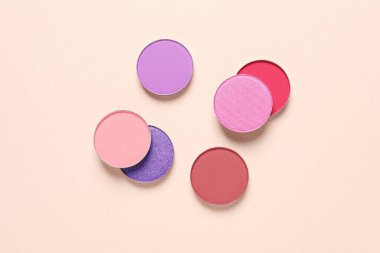 Different beautiful eye shadows on beige background, flat lay