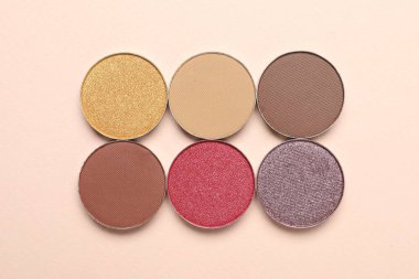 Beautiful eye shadow refill pans on beige background, flat lay
