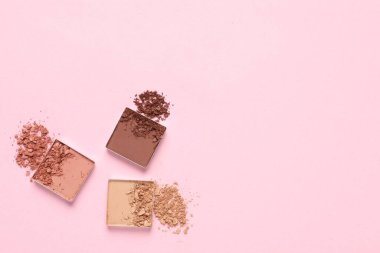 Crushed eye shadows on pink background, flat lay with space for text. Professional makeup product