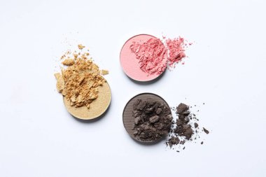 Different crushed eye shadows on white background, flat lay. Professional makeup product