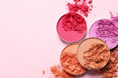 Different crushed eye shadows on pink background, flat lay. Space for text