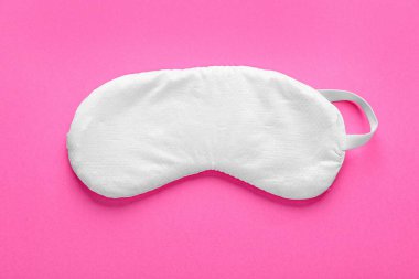 Soft sleep mask on pink background, top view
