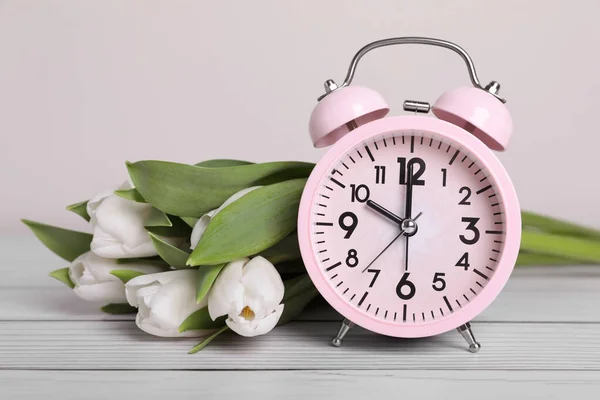 Pink Alarm Clock Beautiful Tulips White Wooden Table Light Background — Stok fotoğraf