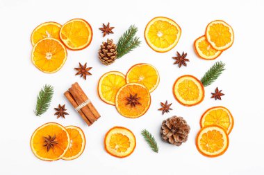 Flat lay composition with dry orange slices, anise stars, cinnamon sticks and fir cones on white background