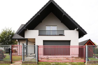 Caddedeki özel evin yanındaki kırmızı ve gri metal kapılar.