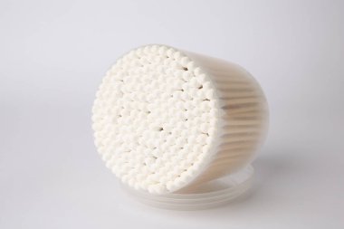 Open container with cotton buds on white background