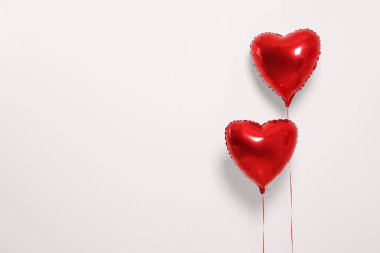 Red heart shaped balloons on white background, space for text
