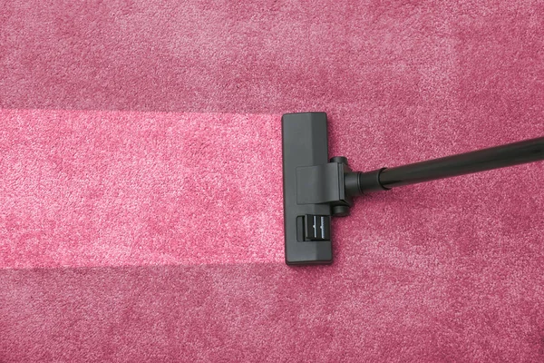 Vacuuming dirty pink carpet. Clean area after using device, top view