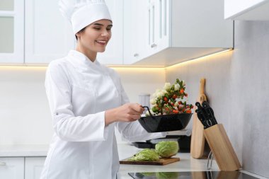 Professional chef cooking delicious salad in kitchen